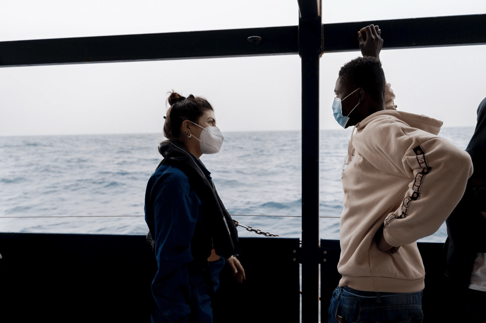 rachele von seewatch im gespräch an bord eines schiffes. sie und der gesprächspartner tragen atemschutz-masken.
